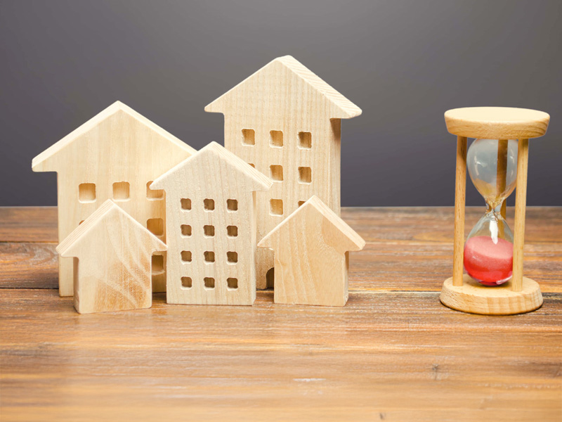 Wooden figures of houses and sand hourglass