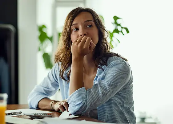 woman lost in thought sitting at a table