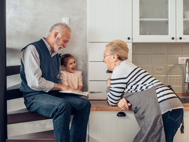 grandparents reading book to granddaughter