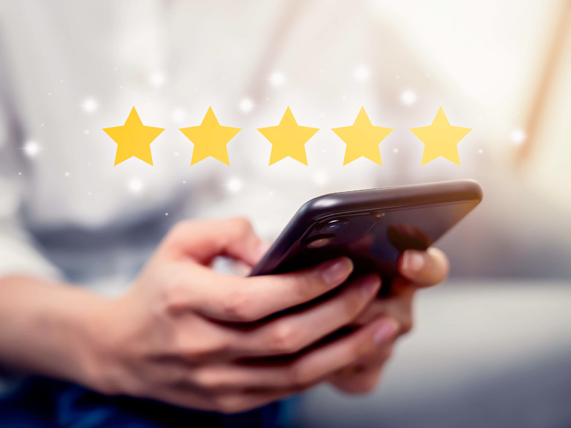 person typing on their phone with stars above it