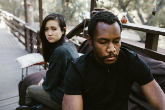 sad couple sitting back to back